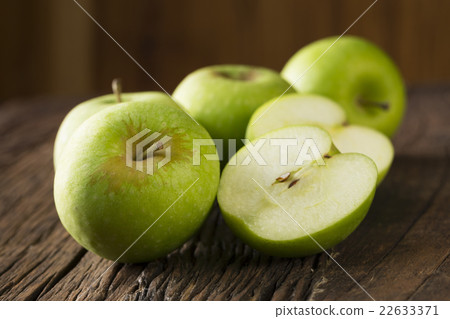 Green apples sitting on a rustic wooden table. Green apples sitting on a rustic wooden table. 22633371