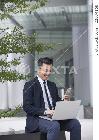 Asian business Man using his laptop outdoors. 22634159