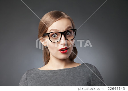Wide-eyed astonished woman over grey background 22643143