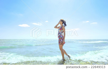 Stock Photo: Young woman standing in sea waves