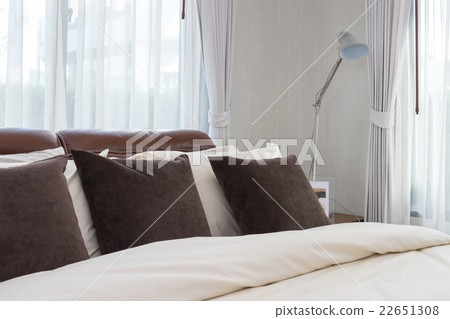 modern bedroom with brown pillows and lamp 22651308