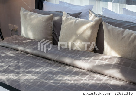 modern bedroom with brown pillows 22651310