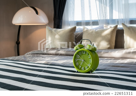 modern bedroom with green alarm clock on bed modern bedroom with green alarm clock on bed 22651311