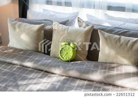 bedroom with green alarm clock and pillows on bed bedroom with green alarm clock and pillows on bed 22651312