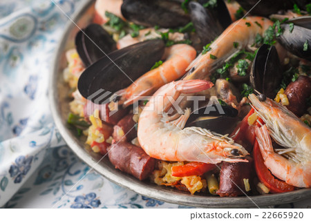 Paella in the metal plate on the beautiful napkin  22665920