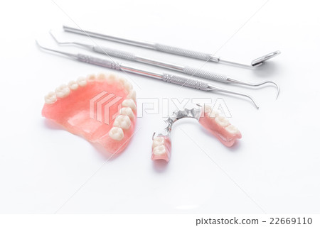 Denture and dental mirror on white background 22669110