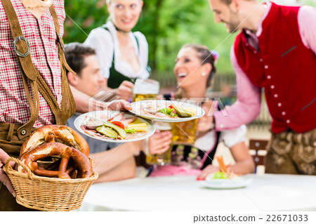 Waiter serving food in Bavarian beer garden 22671033