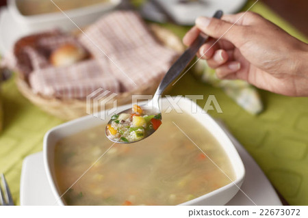 Young woman eating hot and healthy soup 22673072
