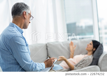Doctor writing on notepad while consulting pregnant woman 22674232