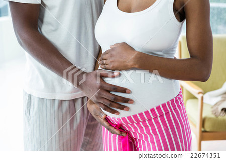 Pregnant couple embracing in bedroom Pregnant couple embracing in bedroom 22674351