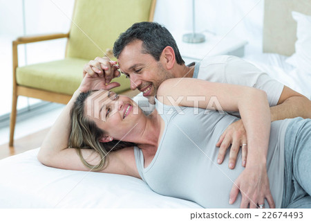 Expecting couple lying on bed and chatting Expecting couple lying on bed and chatting 22674493