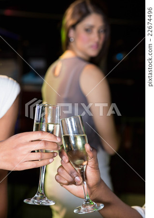 Couple toasting champagne glasses while unhappy looking at them Couple toasting champagne glasses while unhappy looking at them 22674496