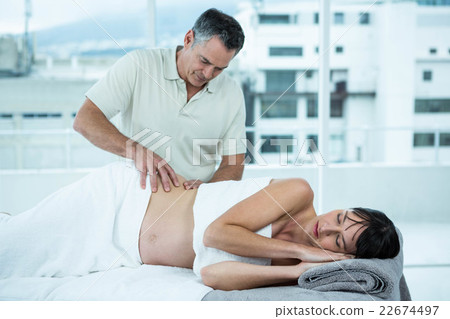 Pregnant woman receiving a back massage from masseur Pregnant woman receiving a back massage from masseur 22674497