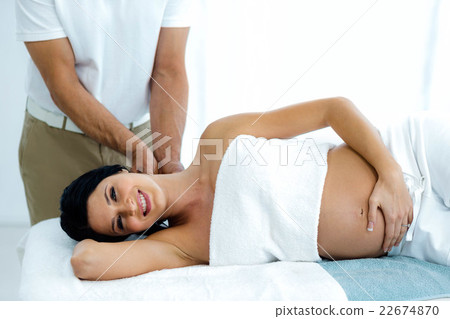 Pregnant woman receiving a back massage from masseur Pregnant woman receiving a back massage from masseur 22674870