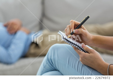 Female doctor writing on notepad while consulting a man Female doctor writing on notepad while consulting a man 22674972