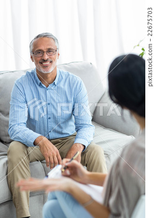 Female doctor writing on clipboard while consulting a man 22675703
