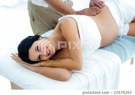 Pregnant woman receiving a back massage from masseur Pregnant woman receiving a back massage from masseur 22676263