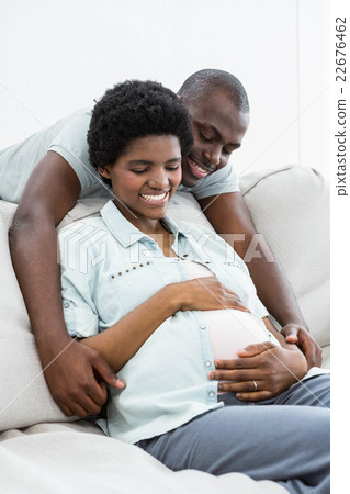 Man embracing pregnant woman from behind 22676462