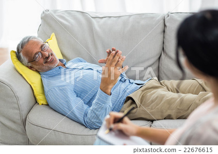 Female doctor writing on notepad while consulting a man 22676615