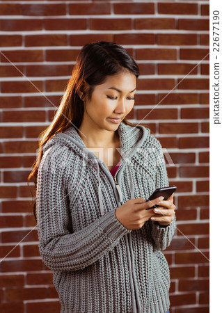 Focused asian woman using smartphone Focused asian woman using smartphone 22677190