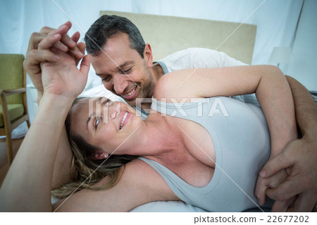 Expecting couple lying on bed and chatting Expecting couple lying on bed and chatting 22677202