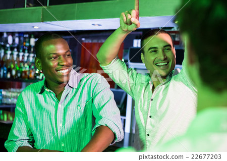 Group of men dancing near bar counter Group of men dancing near bar counter 22677203