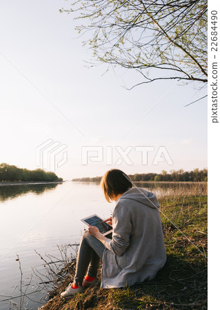 girl working with tablet at the river girl working with tablet at the river 22684490