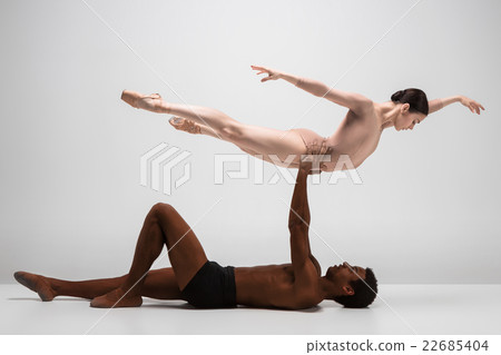 Couple of ballet dancers posing over gray 22685404