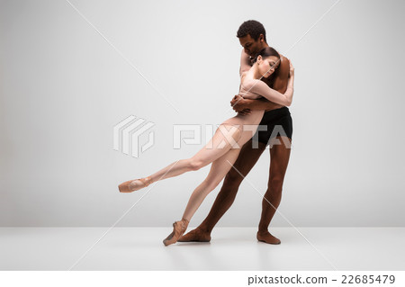Couple of ballet dancers posing over gray Couple of ballet dancers posing over gray 22685479