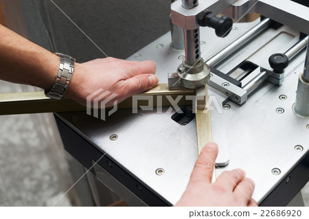 Craftsman working on frame in frameshop. Craftsman working on frame in frameshop. 22686920