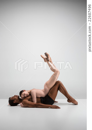 Couple of ballet dancers posing over gray 22687496