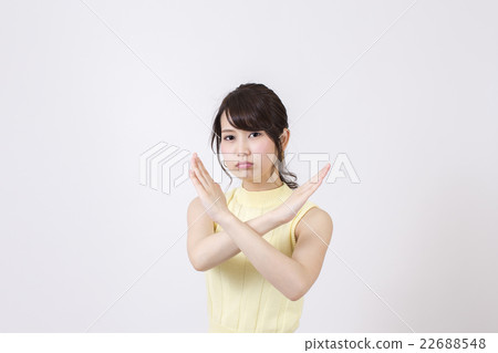 A young woman making a cross mark in a sweet front in front of a white background 22688548