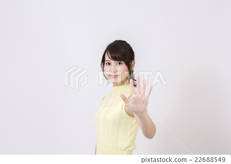 在白色背景前面用左手向前打他的停止的一位小姐 在白色背景前面用左手向前打他的停止的一位小姐 22688549