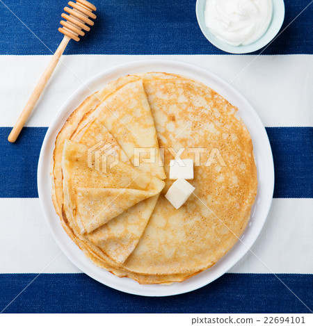 Thin crepes or pancakes with butter and sour cream Thin crepes or pancakes with butter and sour cream 22694101