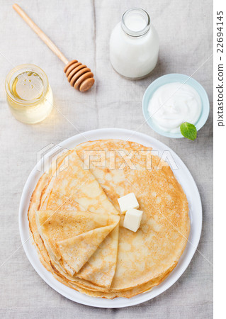 Thin crepes or pancakes with butter and sour cream Thin crepes or pancakes with butter and sour cream 22694145