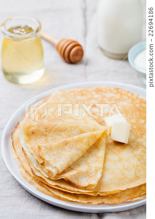 Thin crepes or pancakes with butter and sour cream 22694186