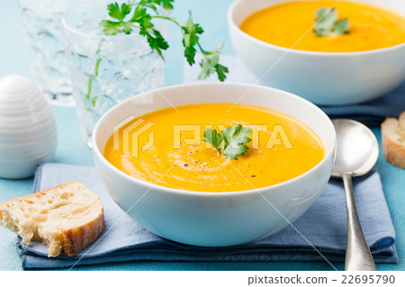 Pumpkin and carrot soup with cream and parsley 22695790