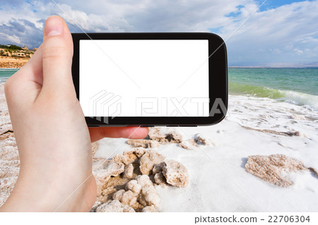 tourist photographs salt coastline of Dead Sea 22706304