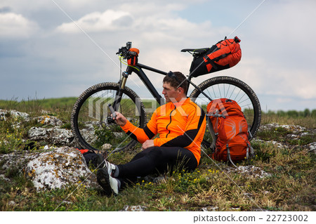 Young Male Cyclist Talking On Cell Phone Young Male Cyclist Talking On Cell Phone 22723002