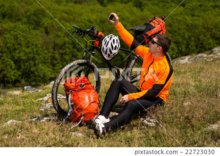 Cyclist taking picture with smart phone. 22723030