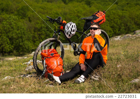 Young Male Cyclist Talking On Cell Phone Young Male Cyclist Talking On Cell Phone 22723031