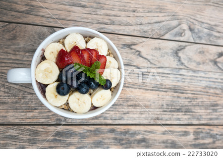Acai bowl strawberry blueberry banana wooden table 22733020