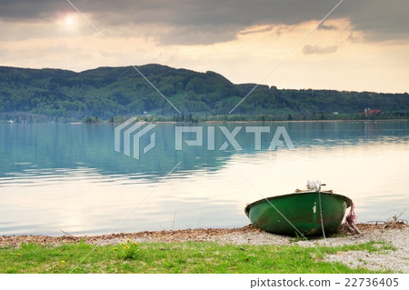 Abandoned fishing paddle boat on bank.Morning lake Abandoned fishing paddle boat on bank.Morning lake 22736405