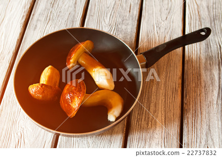 Whole mushrooms on black pan. 22737832