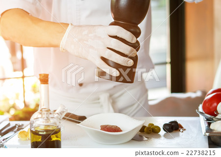 Man's hand holding pepper dispenser. 22738215