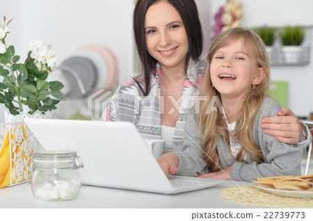 mother and daughter using laptop mother and daughter using laptop 22739773