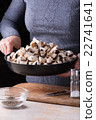 female hands hold fresh mushrooms in the pan 22741641