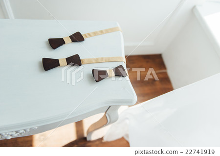 Wooden bow ties on a ivory table Wooden bow ties on a ivory table 22741919