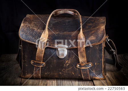 Old leather bag on wooden background 22750563
