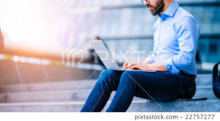 Manager with laptop, sitting on stairs, London 22757277